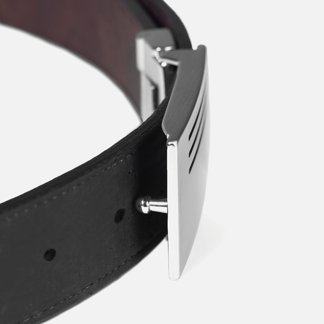 Detail view of Corkor vegan men's reversible cork belt in black with silver plaque buckle and adjustable mechanism