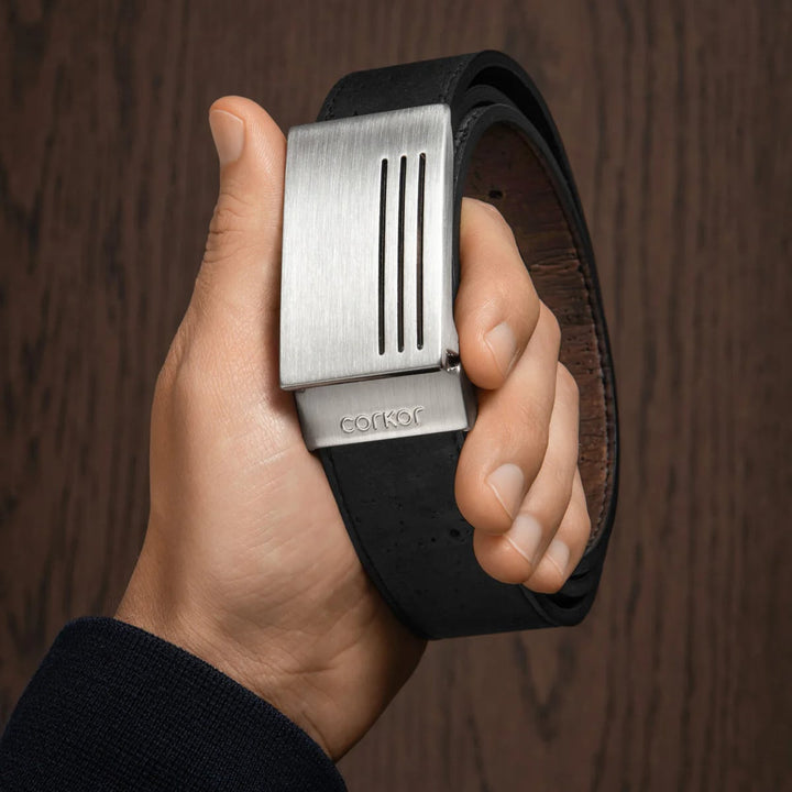 Corkor vegan men's reversible cork belt with silver plaque buckle, shown handheld for detail view