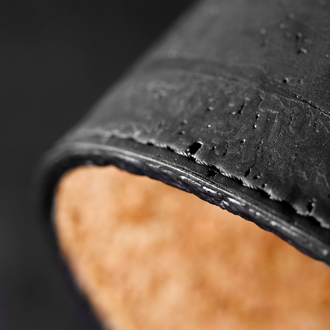 Close-up of Corkor black mouse pad showing its textured surface, rounded edge, and visible stitching