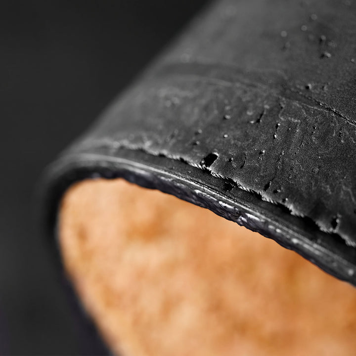 Close-up of Corkor black mouse pad showing its textured surface, rounded edge, and visible stitching