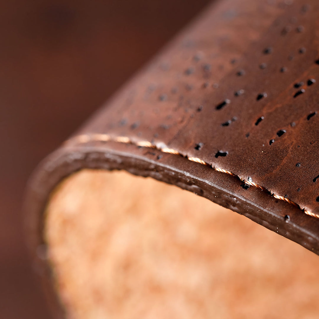 Close-up of Corkor dark brown mouse pad showing its textured surface, rounded edge, and visible stitching