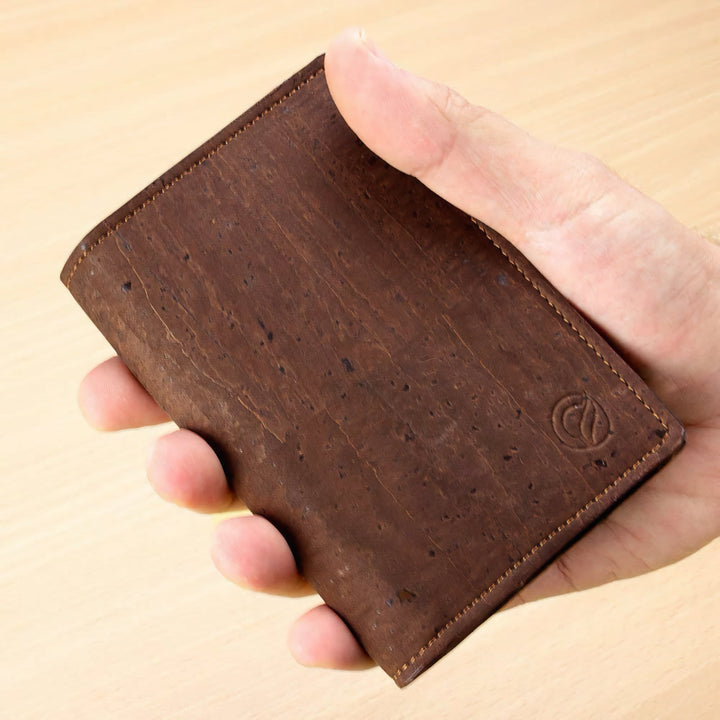 Corkor Vegan Cork Passport Wallet in Dark Brown, shown handheld highlighting slim design and natural cork texture