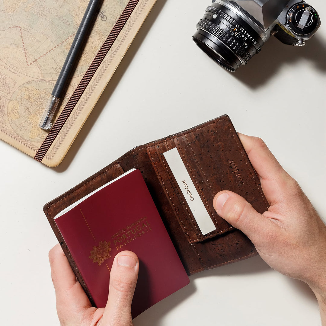 Corkor Vegan Cork Passport Wallet in Dark Brown, lifestyle view with passport and camera on travel desk