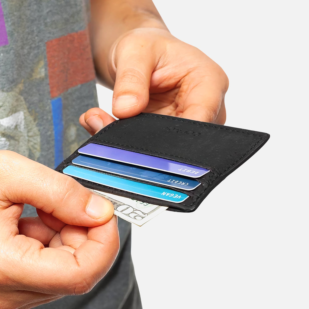 Person holding the black Corkor Vegan Cork Slim Cardholder with cards and cash, showing slim, minimalist, and eco-friendly design