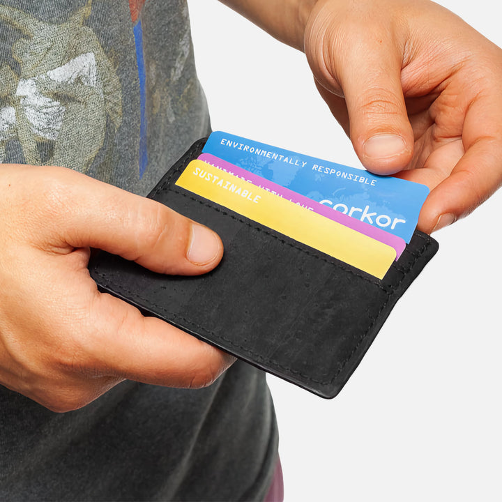 Person holding a black Corkor vegan cork cardholder showing multiple cards in use, slim and minimalist design