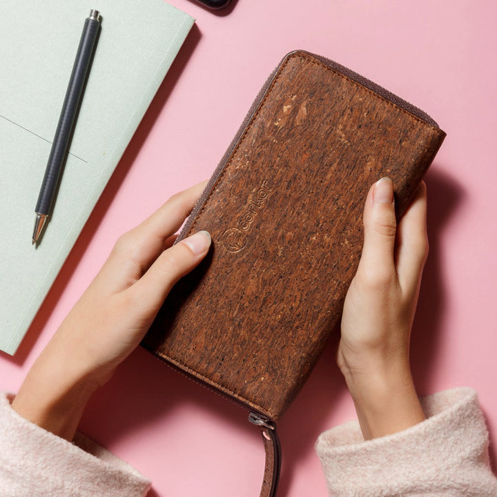 Hands holding Corkor Vegan Cork Women's Long Wallet in trunk finish, emphasizing its natural texture and sustainable design.