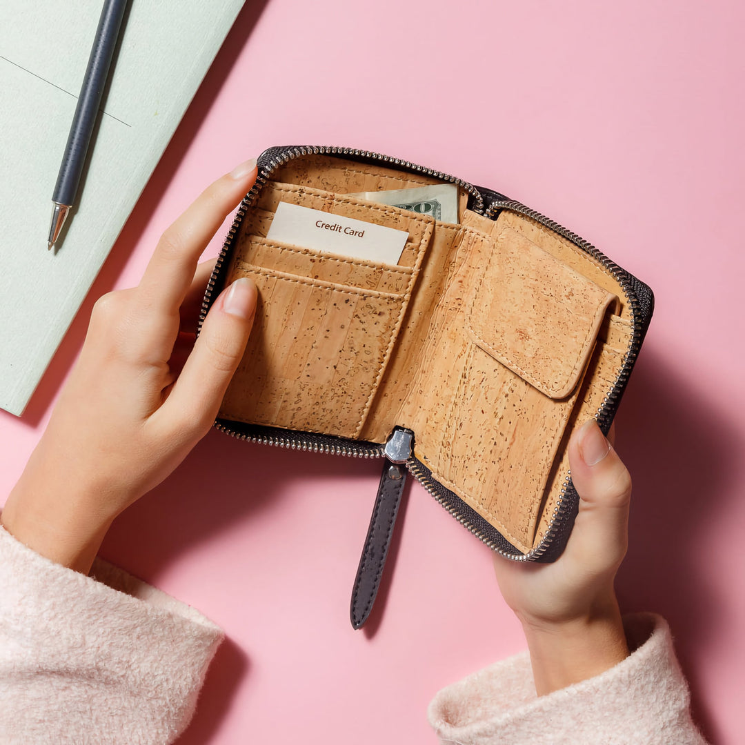 Open Corkor dark brown cork square wallet showing card slots, cash, snap coin pocket and zip edge on pink desk