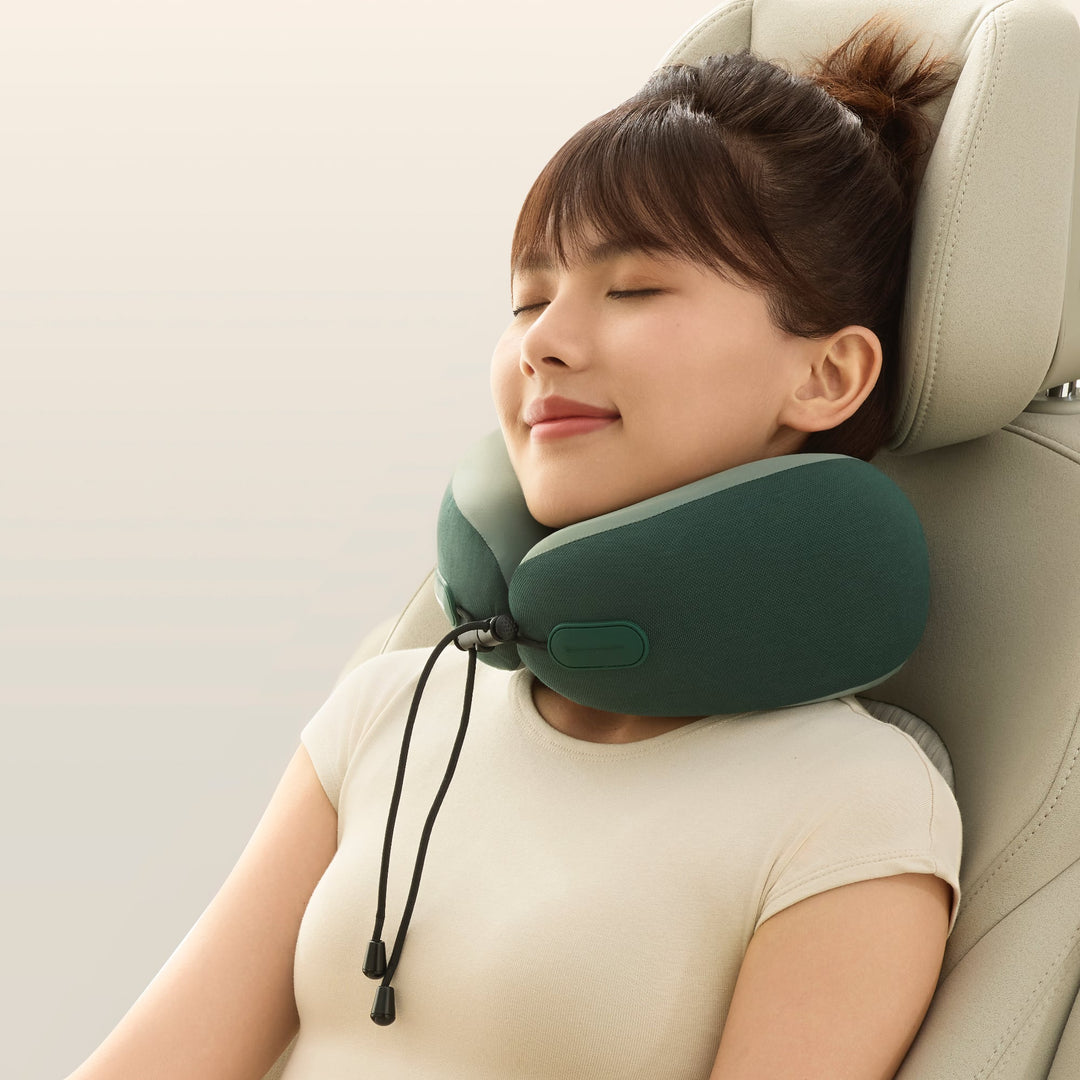 Woman using the EVERYTHINK ES2 green travel neck pillow while resting in a car seat