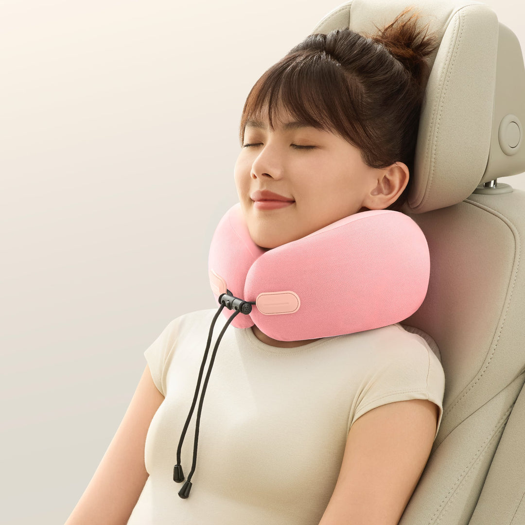 Woman relaxing with the EVERYTHINK ES2 pink travel neck pillow in a car seat, offering soft support for travel naps