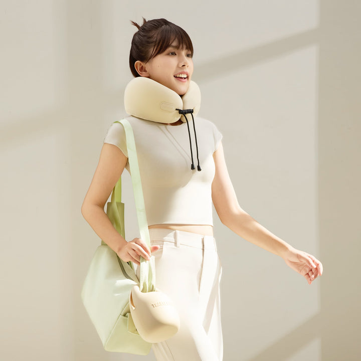 Woman wearing EVERYTHINK ES2 travel neck pillow while walking with carry case attached to tote bag