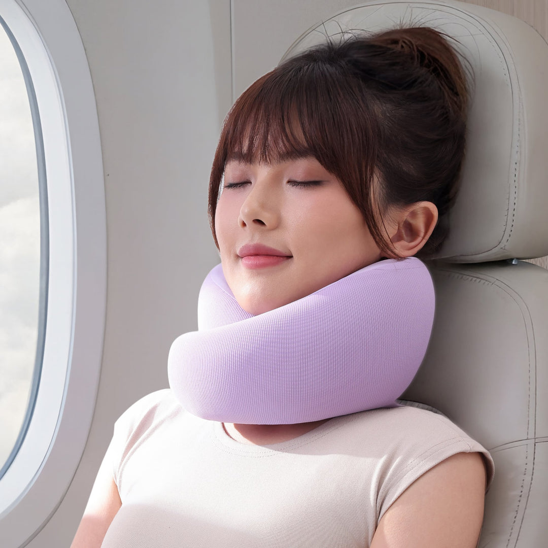Woman using the EVERYTHINK ES3 purple U-shaped travel pillow on a flight seat