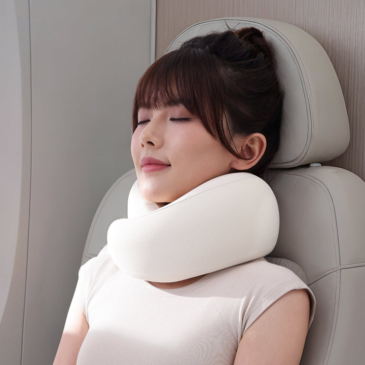 Woman using EVERYTHINK ES3 white U-shaped travel pillow during flight