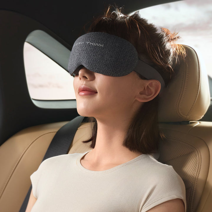 Woman wearing EVERYTHINK VE2 3D Blackout Sleep Mask in gray while resting in a car seat, designed for travel and light-free comfort