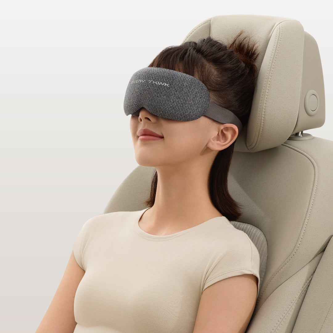 Woman wearing EVERYTHINK VE2 3D Blackout Sleep Mask in gray while seated in a car, ideal for travel and light blocking