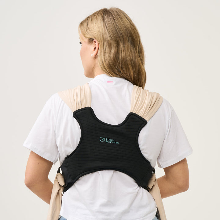 Back view of the Koala Cuddle Band 2 baby carrier in beige, showing the ergonomic and breathable back support panel for even weight distribution.