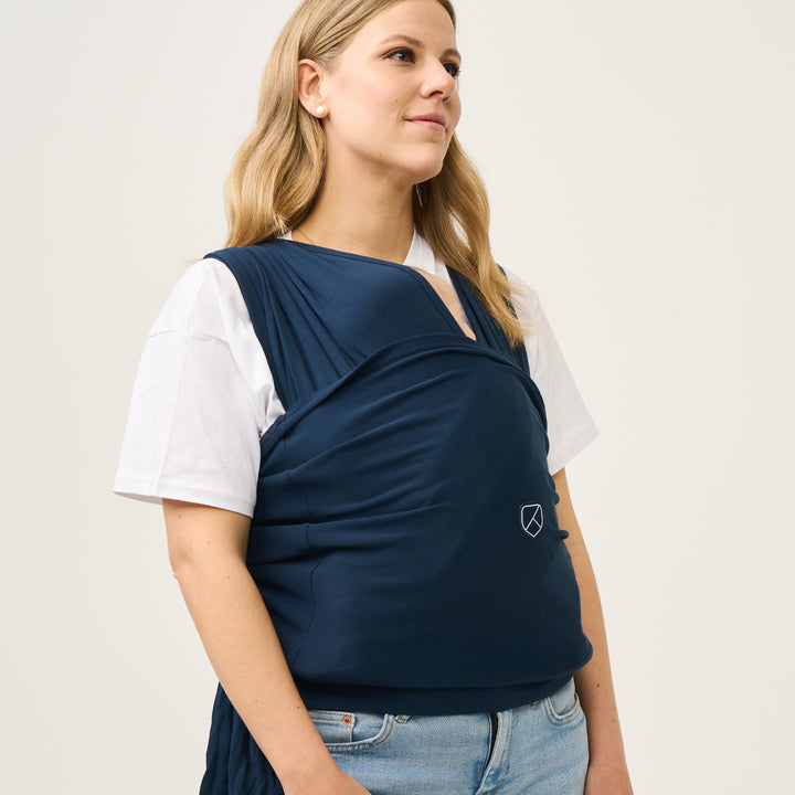 Side view of woman wearing Koala Cuddle Band 2 in dark blue, showcasing supportive and snug babywearing fit