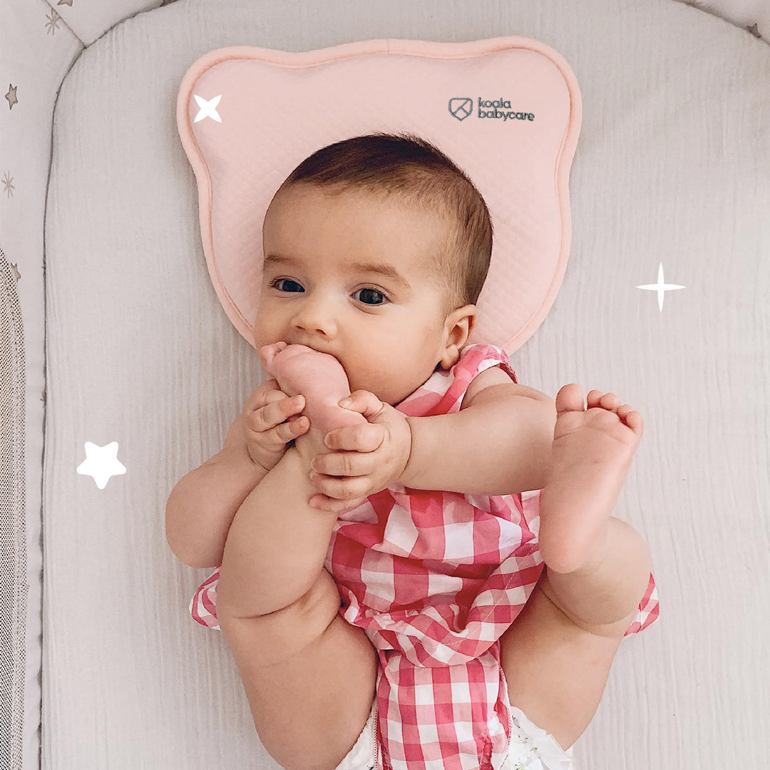 Baby lying on the Koala Babycare Koala Perfect Head pillow in pink, showcasing ergonomic support and comfortable design for infants.