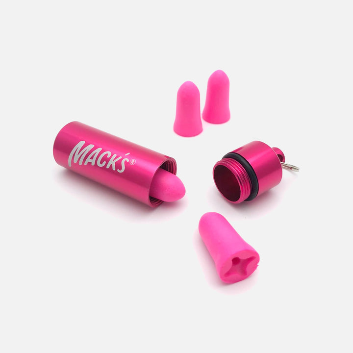 Mack's Dreamgirl Soft Foam Earplugs in pink, displayed alongside a pink aluminum travel case with a screw-top lid.