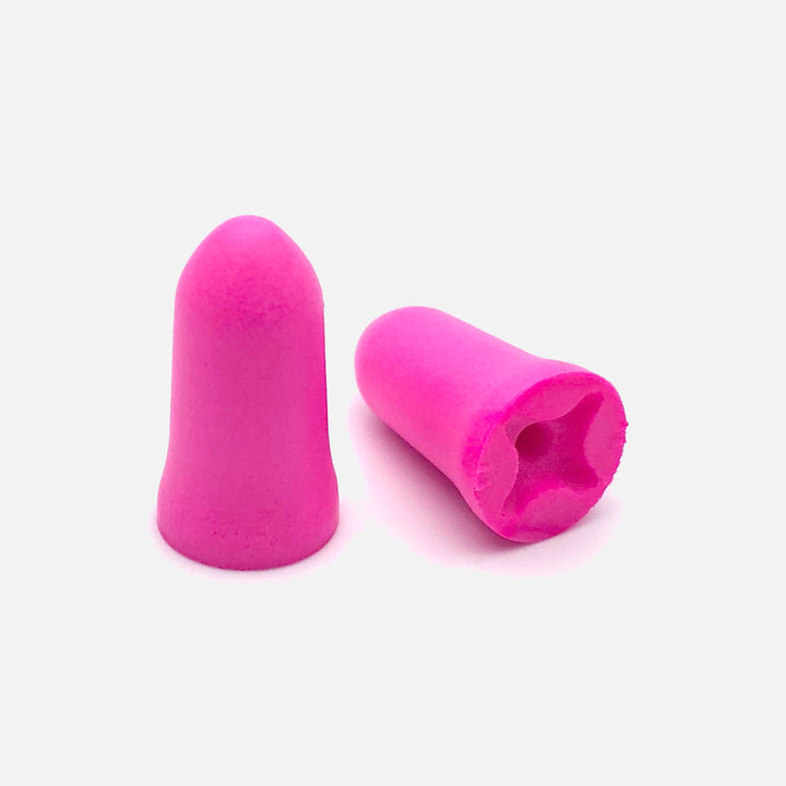 Close-up of Mack's Dreamgirl Soft Foam Earplugs, pink, designed for small or sensitive ear canals, featuring a contoured shape.