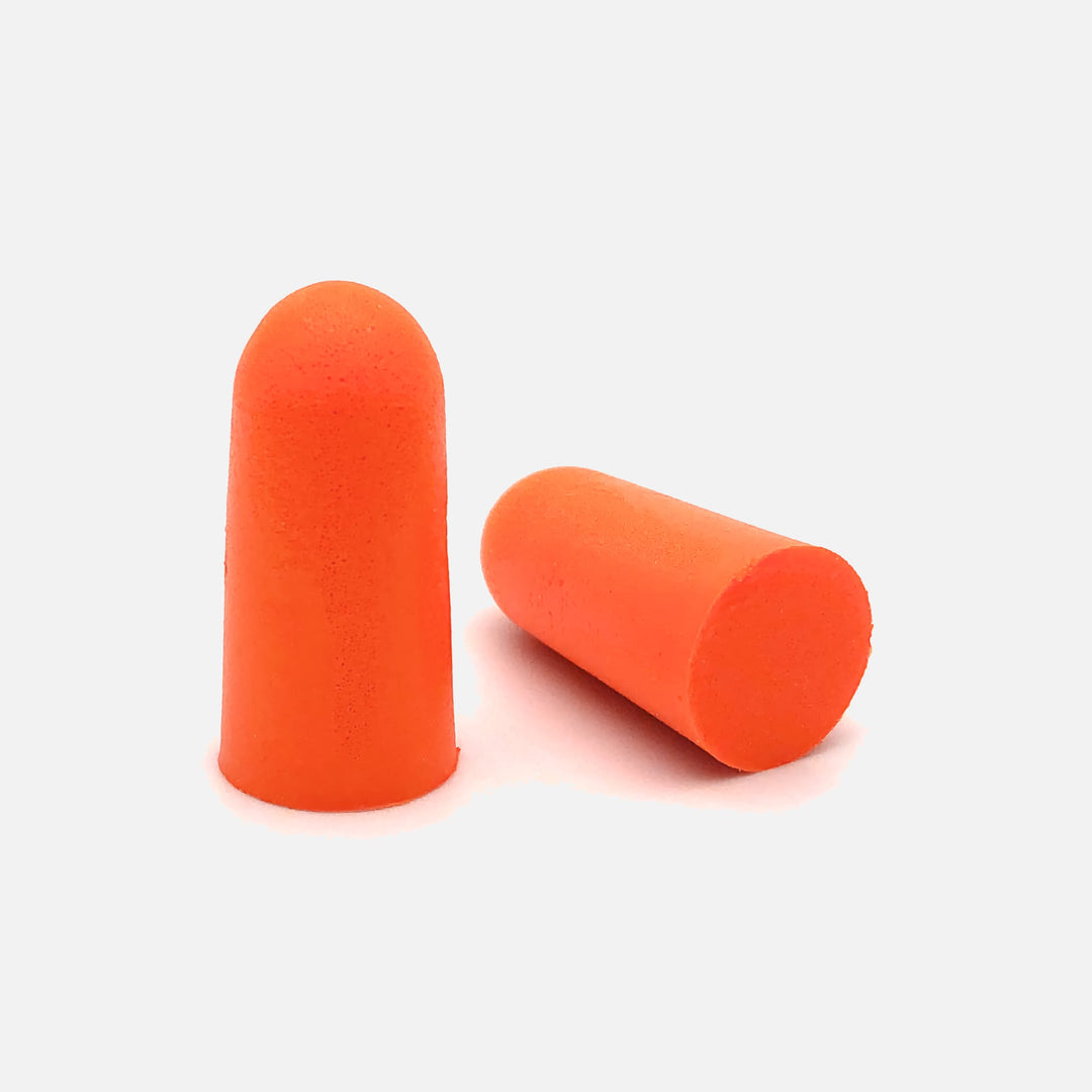 Close-up of orange Mack's soft foam earplugs, ergonomic design for comfort and noise reduction.