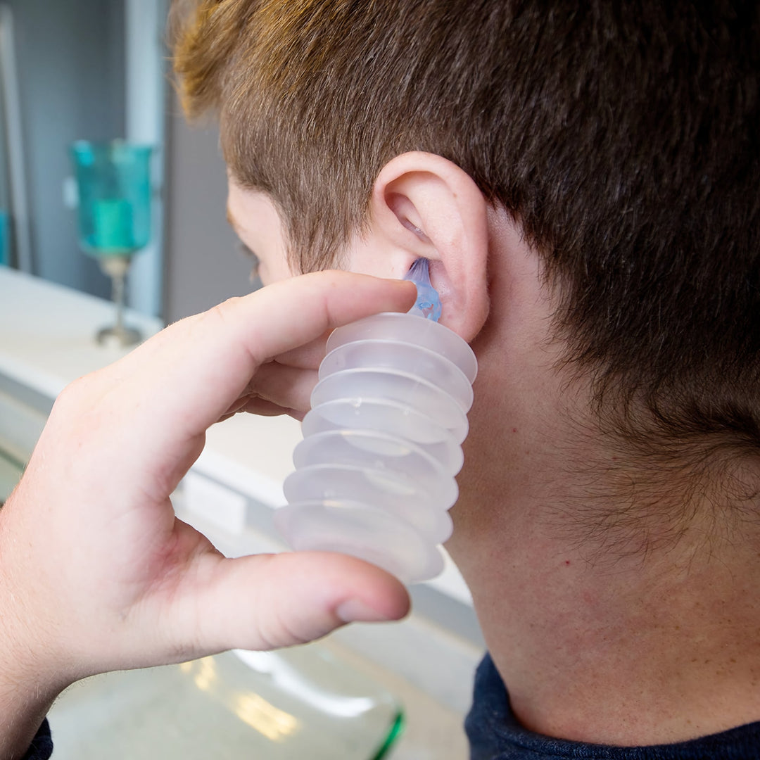 Man using Mack's ProRinse earwax removal syringe with tri-stream tip for ear cleaning at home