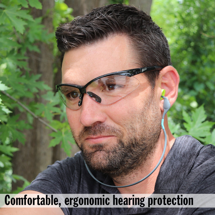 Man wearing Mack's Hi Viz Banded Foam Earplugs with fluorescent yellow-green plugs for ergonomic hearing protection outdoors.