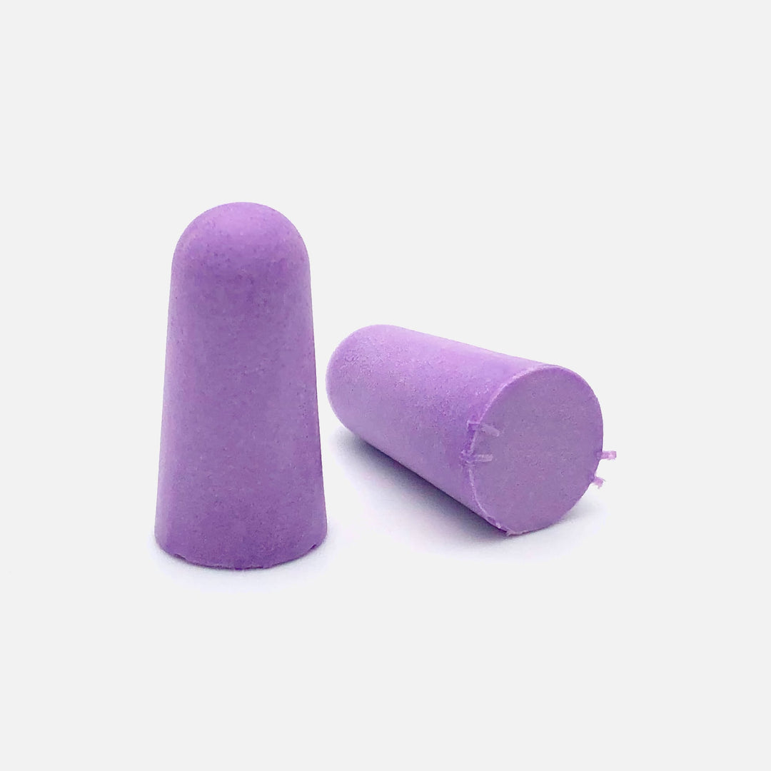 Close-up of two purple soft foam earplugs on a clean white background