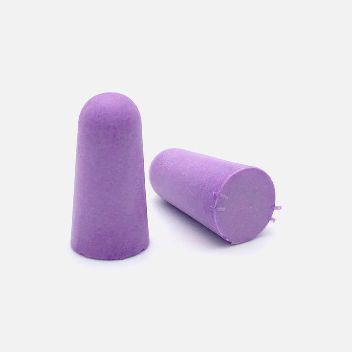 Close-up of two purple soft foam earplugs on a clean white background