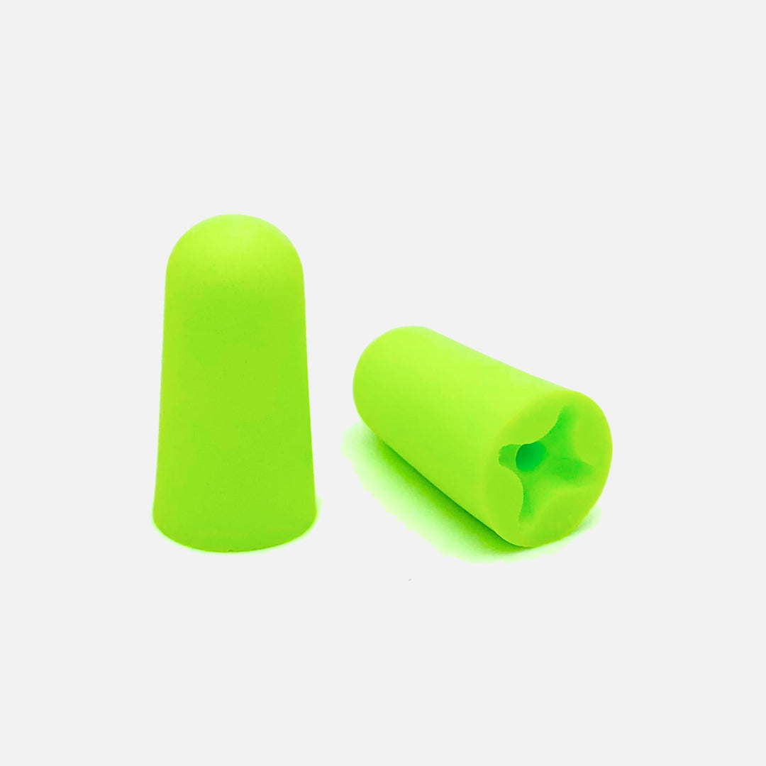 Close-up of Mack's Snore Blockers soft foam earplugs in bright green, designed for comfort and effective noise reduction
