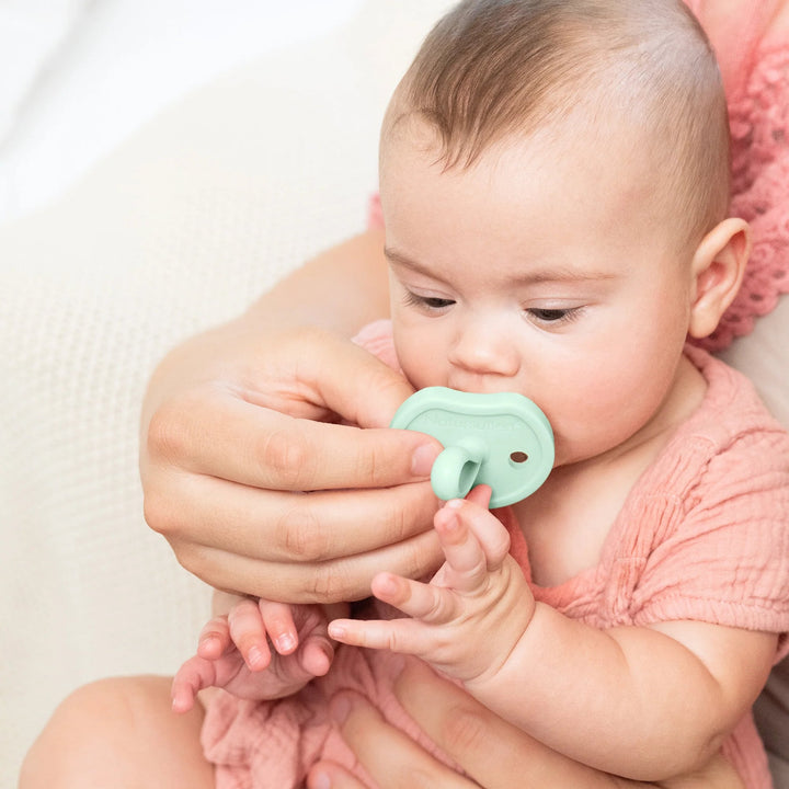 Baby using Natursutten Butterfly Orthodontic Pacifier in Jade Mist, held by a parent for soothing comfort.