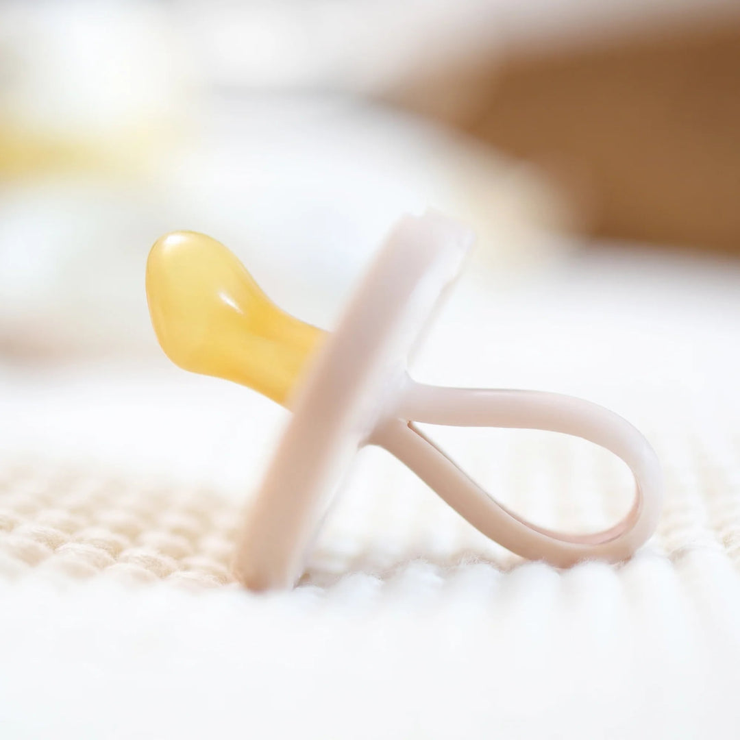 Side view of Natursutten Butterfly Orthodontic Pacifier in Pale Blush, showcasing its ergonomic and natural rubber design.