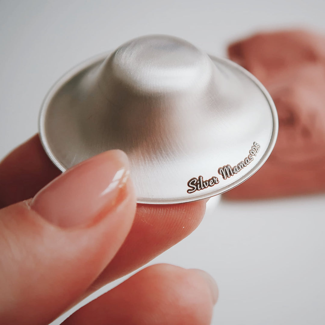 Close-up of Silver Mamas 925 sterling silver nursing cup held in hand, showcasing its smooth craftsmanship.